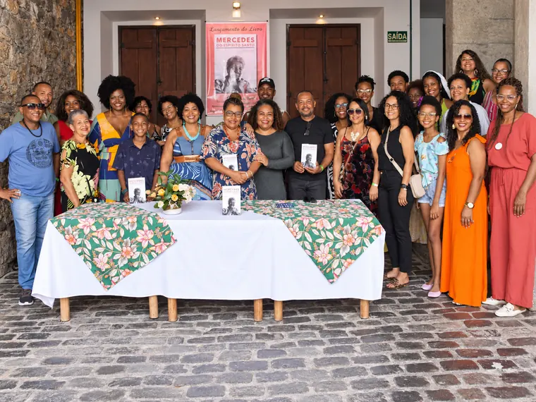 Família e amigos reunidos diante da mesa de autógrafos no lançamento do livro na Casa do Benin